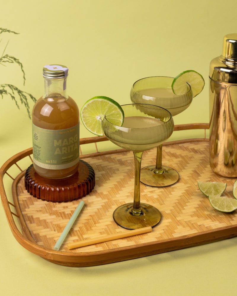 Here's How Margarita Mini Mixer, two glasses with lime, shaker, straws on a bamboo tray.