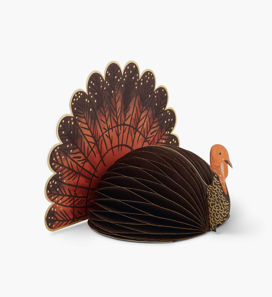 Rifle Paper Co. Turkey Honeycomb Decor. Festive Thanksgiving turkey decoration with a brown honeycomb body, orange head, and fan tail.